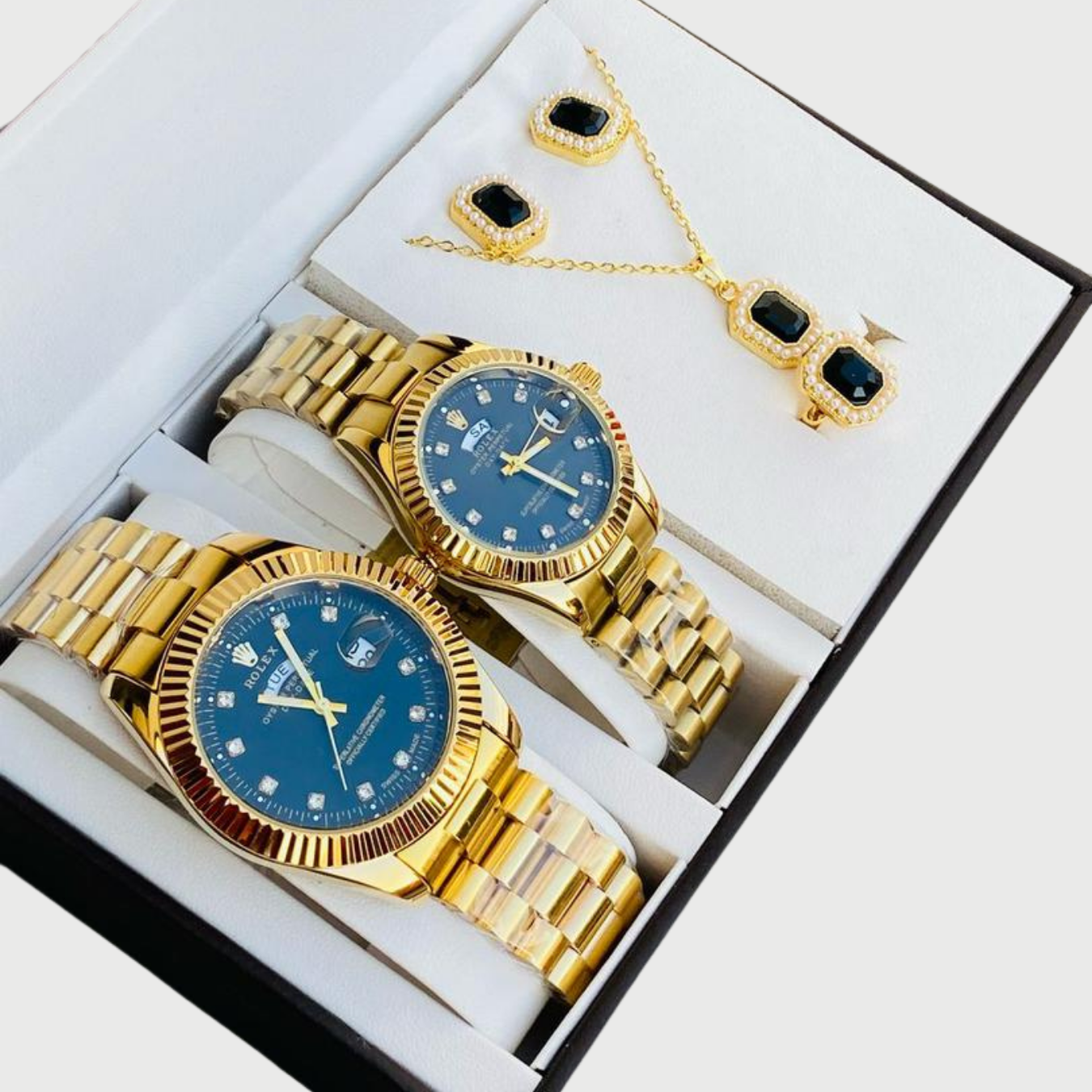 Gold watches with blue faces and matching jewelry set in a box