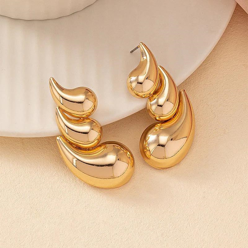 Gold earrings on a beige background