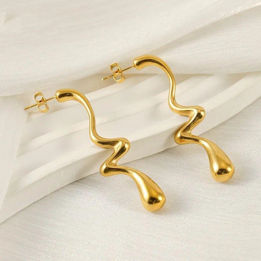 Gold hoop earrings on a light beige background