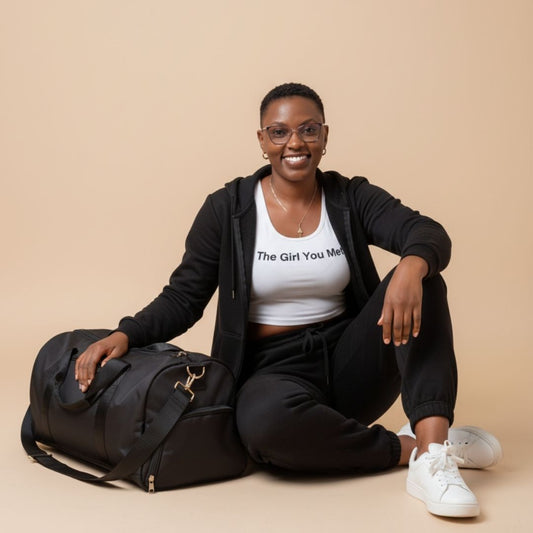 Woman sitting with a black duffel bag on a beige background