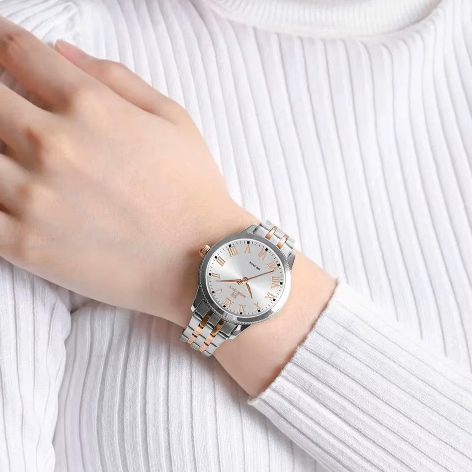 Silver watch on a wrist with a white sweater background
