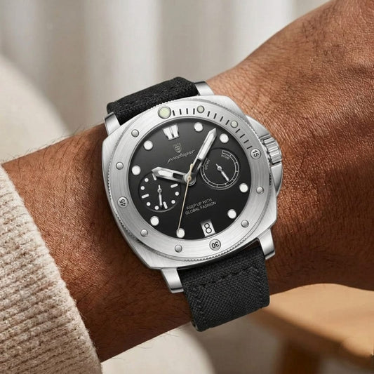 Silver watch with black strap on a wrist against a neutral background