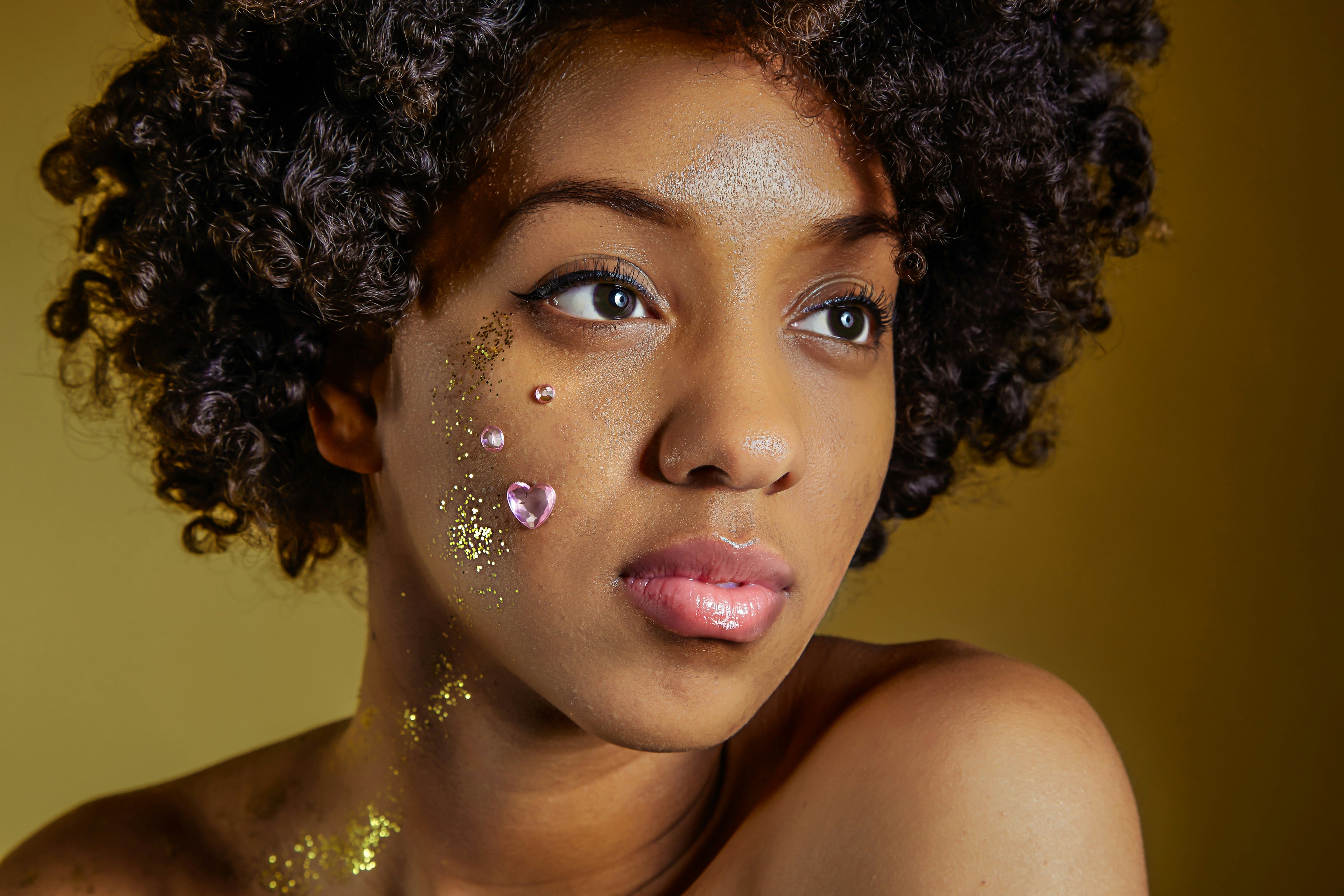 Woman with decorative face paint against a yellow background