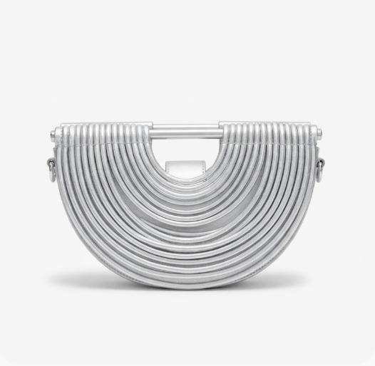 A silver metallic semi-circular clutch bag with concentric ridges and a top handle, shown on a light gray background.