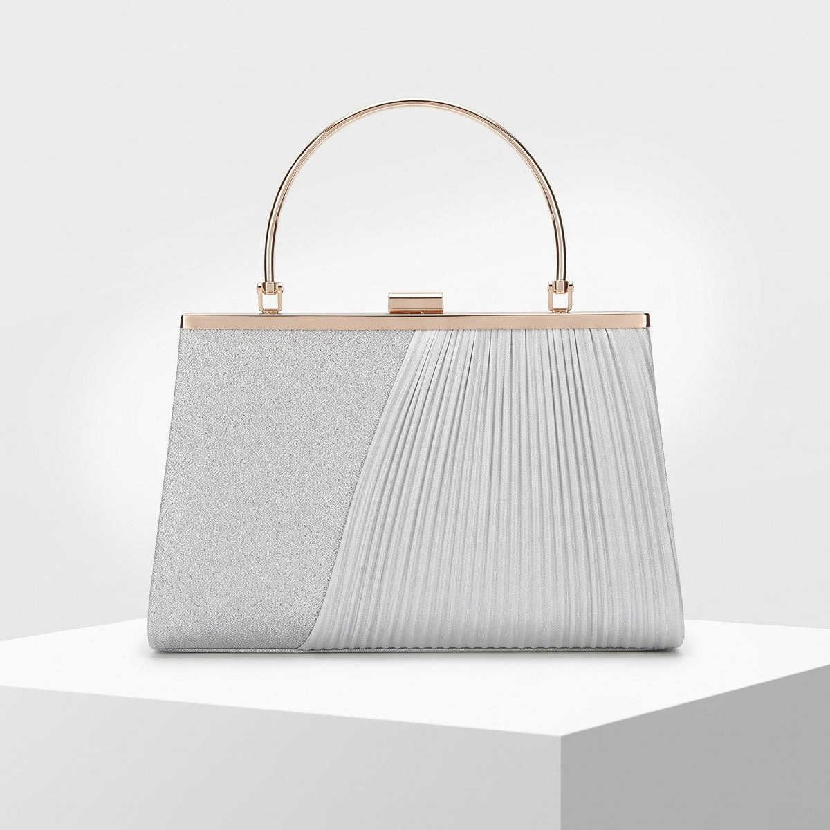 A structured evening clutch bag with a dual-texture design, featuring a glittery silver left panel and a pleated white right panel, with a gold-tone metal handle and frame.