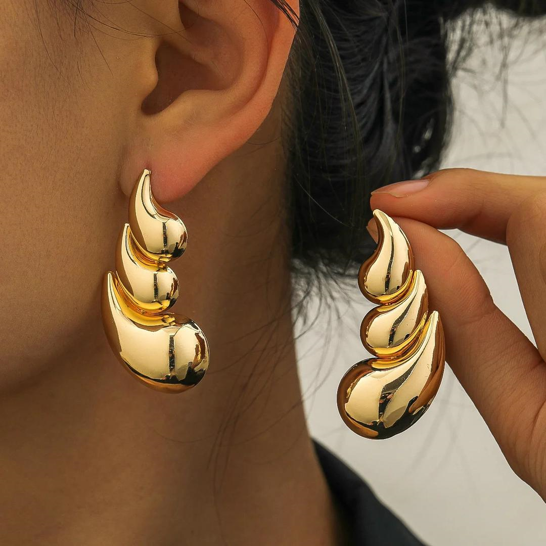 Gold earrings being worn and held up to the ear