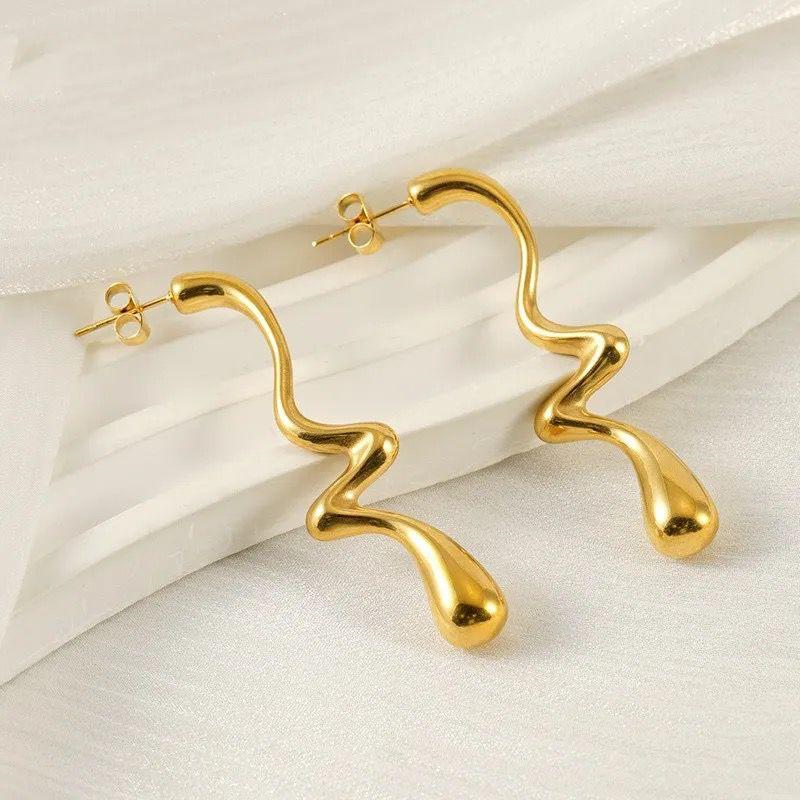 Gold hoop earrings on a light beige background