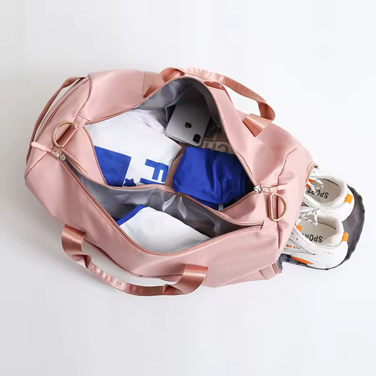 Pink duffel bag with shoes and clothes on a white background