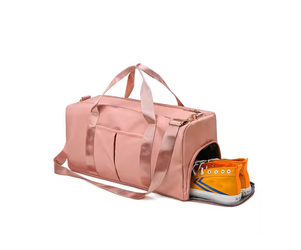 Pink duffel bag with an orange sneaker peeking out on a white background