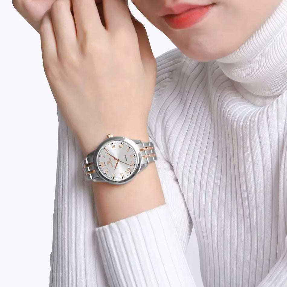 Silver wristwatch on a person's wrist with a white background